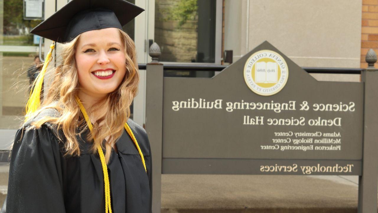 Lois Montgomery, Geneva graduate of 2019, is pictured next to the Science and Engineering Building sign on campus in her graduation cap and gown.